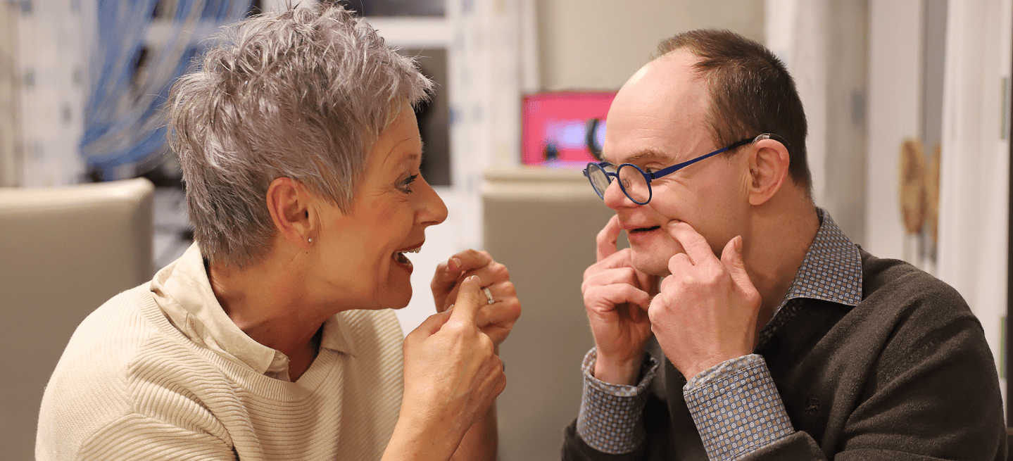 Medewerker en bewoner die samen lachen