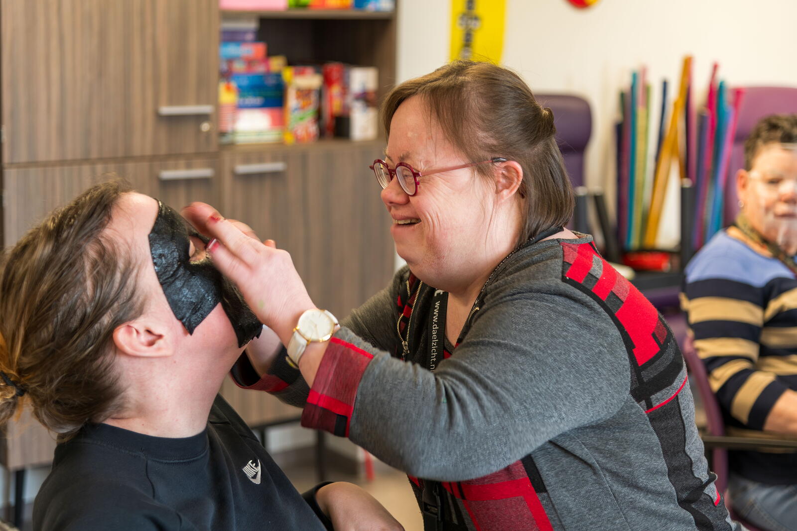 Bewoner die een gezichtsmasker op doet bij een vrijwilliger